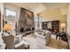Spacious living room featuring a stone fireplace, large windows, and comfortable seating at 6922 W Walden Pl, Littleton, CO 80128