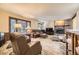 Comfortable living room featuring a stone fireplace and large windows at 6922 W Walden Pl, Littleton, CO 80128