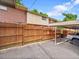 Fenced backyard with brick building, carport and partial view of car at 12664 W Virginia Ave, Lakewood, CO 80228