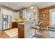 Eat-in kitchen with breakfast bar seating, stainless appliances, and exposed brick wall at 2224 N Humboldt St, Denver, CO 80205