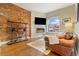 Inviting living room featuring a brick accent wall, fireplace, and hardwood floors at 2224 N Humboldt St, Denver, CO 80205