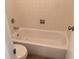 Bathroom featuring a tiled tub and shower with toilet at 8826 E Florida Ave # 103, Denver, CO 80247