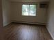 A well-lit bedroom featuring wood-look flooring, large window, and air conditioner at 8826 E Florida Ave # 103, Denver, CO 80247