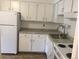 A well-lit kitchen with white cabinets, stainless sink, and electric range at 8826 E Florida Ave # 103, Denver, CO 80247