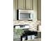 Close-up of the kitchen appliances and backsplash with stainless steel microwave and gas range at 5282 E 116Th Ave, Thornton, CO 80233