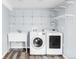 A laundry room with wooden floors, new appliances, sink, and storage at 5282 E 116Th Ave, Thornton, CO 80233