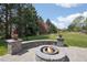 Backyard with a stone fire pit, lush grass, and mature trees at 6180 E Quincy Ave, Cherry Hills Village, CO 80111