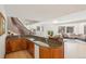 Open-concept kitchen with granite countertops, wood cabinetry, and views into living and stairwell at 6180 E Quincy Ave, Cherry Hills Village, CO 80111