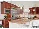 An open kitchen with cherry cabinets, stainless steel appliances, and granite countertops at 6180 E Quincy Ave, Cherry Hills Village, CO 80111