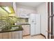 Cozy kitchenette with a sink, granite countertops, a microwave, and a refrigerator at 6180 E Quincy Ave, Cherry Hills Village, CO 80111