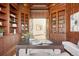 A beautiful office with wood paneled walls, coffered ceiling, and built-in cabinets at 6180 E Quincy Ave, Cherry Hills Village, CO 80111