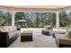 Outdoor covered patio with comfortable seating and a view of the wooded backyard and gazebo at 6180 E Quincy Ave, Cherry Hills Village, CO 80111