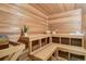 Cedar sauna room with built-in benches, plant, and wood-paneled walls and ceiling at 6180 E Quincy Ave, Cherry Hills Village, CO 80111