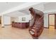 Sweeping wood staircase leading to the lower level of the home, adjoined with a wet bar and living area at 6180 E Quincy Ave, Cherry Hills Village, CO 80111