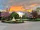 Circular driveway featuring a lighted fountain, surrounded by blossoming trees and professionally maintained landscaping at 6180 E Quincy Ave, Cherry Hills Village, CO 80111
