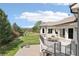 A view from the balcony overlooking the backyard, showing the fire pit, and lush landscaping at 6180 E Quincy Ave, Cherry Hills Village, CO 80111