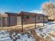 House exterior with covered patio and snowy yard at 4348 S Jason St, Englewood, CO 80110