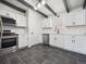 Modern kitchen with white shaker cabinets, stainless steel appliances, and dark tile floors at 4348 S Jason St, Englewood, CO 80110