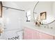 Bathroom featuring pink cabinets, a black framed mirror, and modern fixtures at 1641 S Corona St, Denver, CO 80210