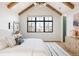 Bright bedroom features vaulted ceilings, exposed beams, and a large window overlooking the neighborhood at 1641 S Corona St, Denver, CO 80210