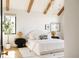 Modern bedroom with white walls, wood beam ceiling, statement lighting, and neutral decor at 1641 S Corona St, Denver, CO 80210