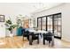 Open dining area with a white table, black chairs, modern lighting, and a stylish bar area with blue cabinets at 1641 S Corona St, Denver, CO 80210