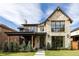 Beautiful stone exterior with black trim, large windows, and a covered porch, sits on a lush lawn at 1641 S Corona St, Denver, CO 80210