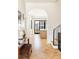 Inviting foyer with hardwood floors in a herringbone pattern, arched doorway, and view to the kitchen at 1641 S Corona St, Denver, CO 80210