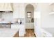 Bright kitchen featuring white cabinets, stainless steel appliances, a marble countertop, and hardwood floors at 1641 S Corona St, Denver, CO 80210