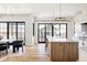 Bright kitchen and dining area with wood floors, a large center island, modern lighting, and access to the backyard at 1641 S Corona St, Denver, CO 80210