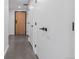 Hallway with wood door and gray floors leading to additional rooms at 1601 Park Ave # 112, Denver, CO 80218