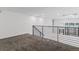 Upstairs carpeted hallway featuring black metal handrails and a view of the windows below at 1601 Park Ave # 112, Denver, CO 80218