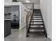 View of kitchen with black stainless refrigerator and stairs with metal railings in view at 1601 Park Ave # 112, Denver, CO 80218
