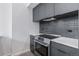 Contemporary kitchen features stainless steel oven and cooktop, gray cabinets, and white countertops at 1601 Park Ave # 112, Denver, CO 80218