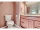 A bathroom featuring a toilet and a wood vanity with drawers and cabinet at 701 Harlan St # E27, Lakewood, CO 80214