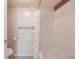 Bathroom with a bathtub and shower combination featuring neutral accents and tilework at 701 Harlan St # E27, Lakewood, CO 80214
