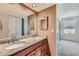 Bathroom with double vanity featuring granite countertops and neutral color palette with adjacent bedroom at 701 Harlan St # E27, Lakewood, CO 80214