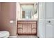 Bright bathroom with granite counters, wood cabinets, and updated fixtures at 701 Harlan St # E27, Lakewood, CO 80214