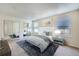 Bright bedroom with a large bed, mirrored closet doors, and natural light from two windows at 701 Harlan St # E27, Lakewood, CO 80214