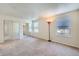 A bright bedroom is empty and ready for decor, with large mirrored closet doors at 701 Harlan St # E27, Lakewood, CO 80214