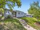 Charming single-story home with landscaped front yard and inviting entryway, under a sunny, blue sky at 835 Knox Ct, Denver, CO 80204