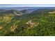 Scenic aerial view of the beautiful home nestled amongst the dense forestry at 13007 Kuehster Rd, Littleton, CO 80127
