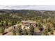 Sweeping aerial view showing the home's setting, long driveway, and lush forest surroundings at 13007 Kuehster Rd, Littleton, CO 80127