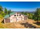 Large barn with multiple garage doors, a green roof, and mountain views at 13007 Kuehster Rd, Littleton, CO 80127