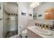 Well-lit bathroom featuring a tiled glass shower, marble countertop, and decorative wall art at 13007 Kuehster Rd, Littleton, CO 80127