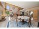 An open-concept dining room features a round table, a blue rug, and an entrance to the kitchen and living room at 13007 Kuehster Rd, Littleton, CO 80127