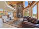 A sprawling living room offers a floor-to-ceiling stone fireplace and ample natural light through large windows at 13007 Kuehster Rd, Littleton, CO 80127