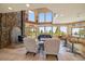 A cozy living room with high ceilings, stone fireplace, bar, and large windows with scenic views at 13007 Kuehster Rd, Littleton, CO 80127