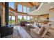 A bright living room with floor-to-ceiling windows, a stone fireplace, and an open layout to the kitchen at 13007 Kuehster Rd, Littleton, CO 80127