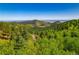 Expansive mountain view showcases rolling hills and lush evergreen forests under a clear blue sky at 13007 Kuehster Rd, Littleton, CO 80127